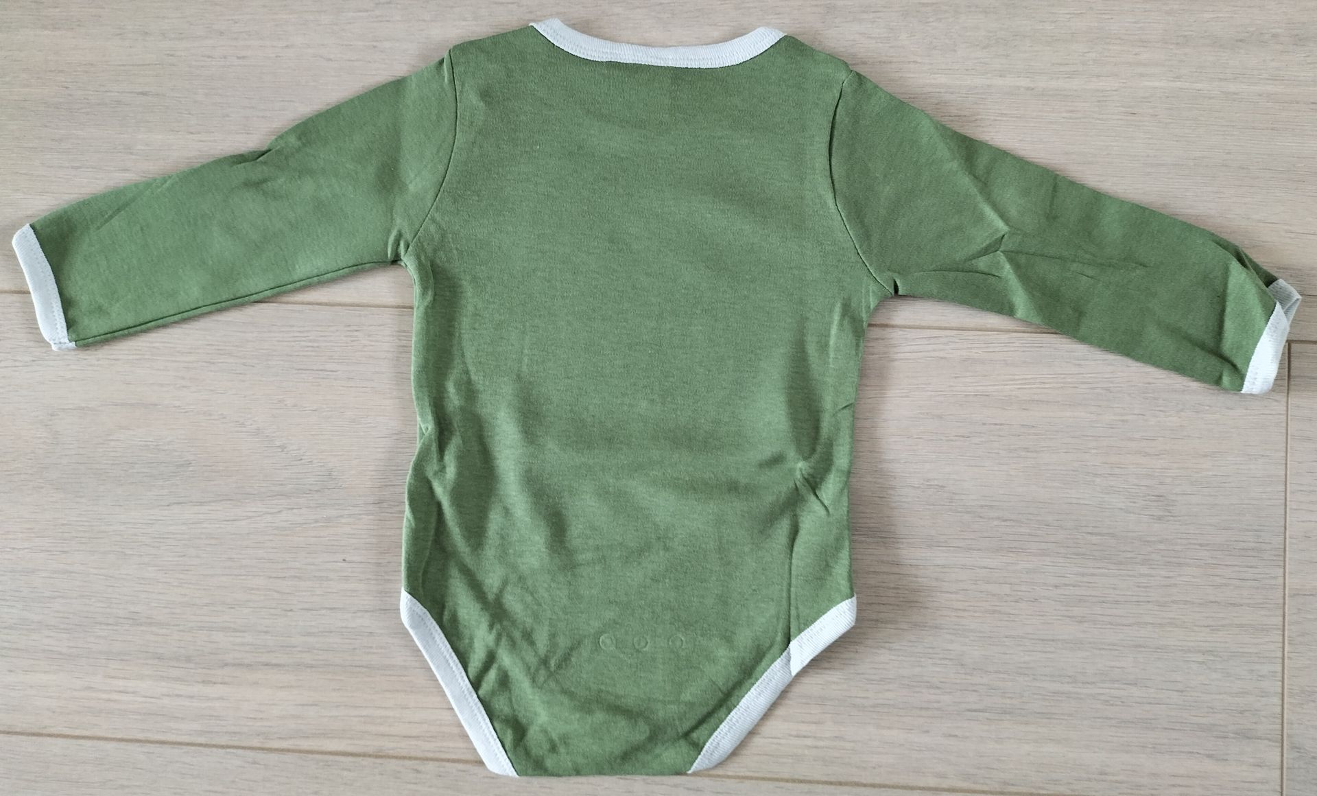 Groene Winnie de Pooh babyromper met witte bies.
