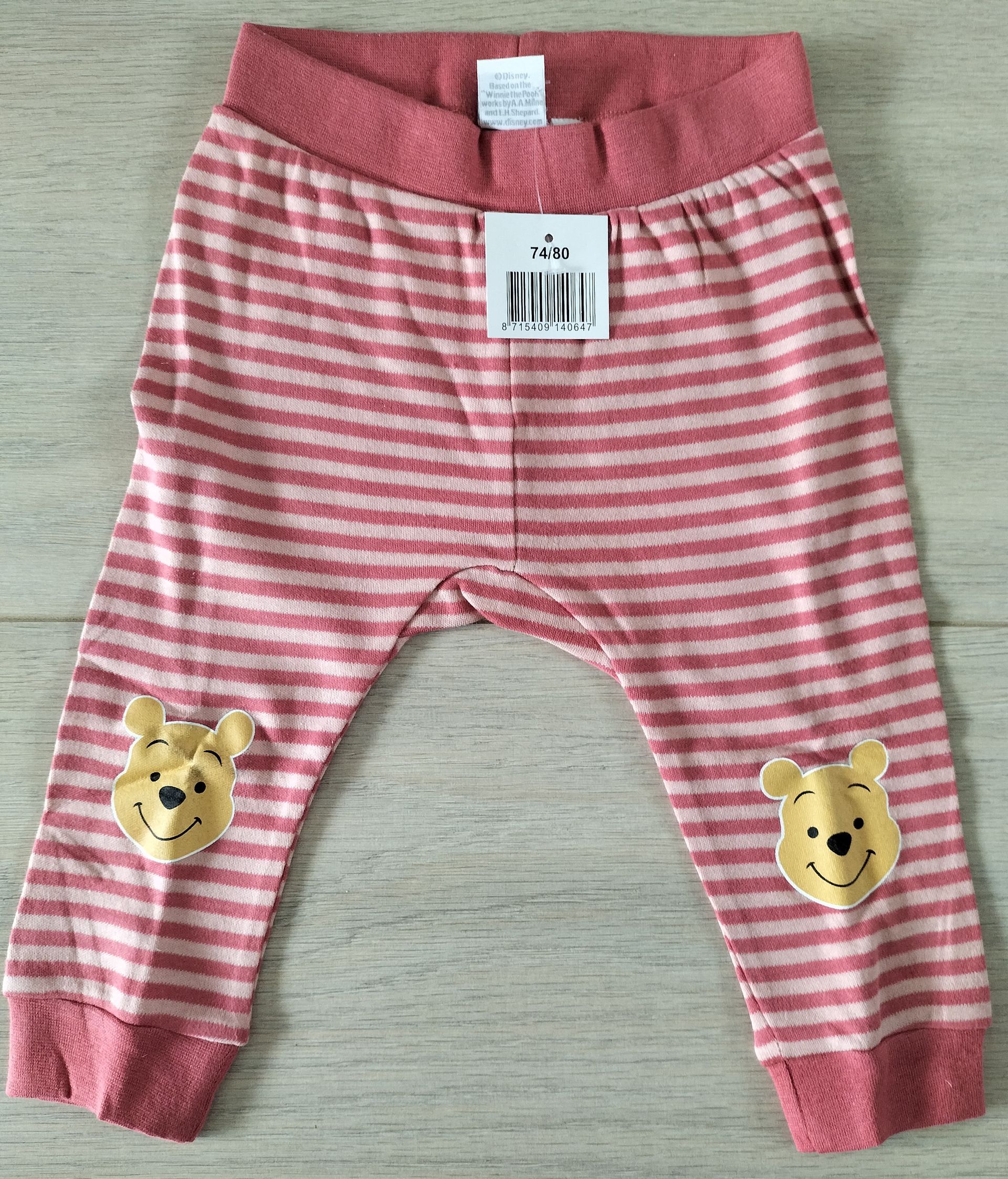 Roze gestreepte babybroek met Winnie de Pooh-patches.