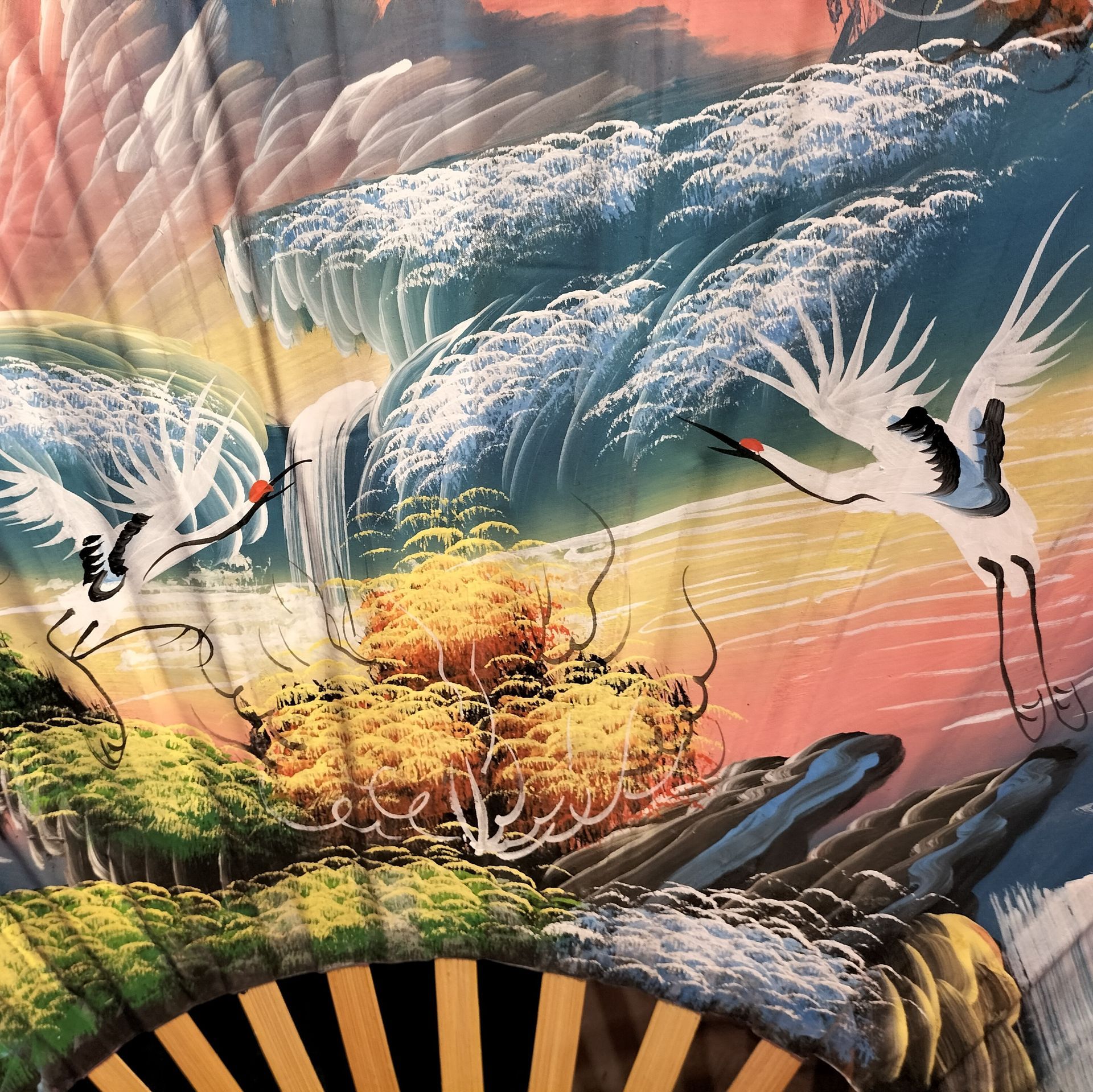 Detail waaier met twee kraanvogels die vliegen boven een waterval.