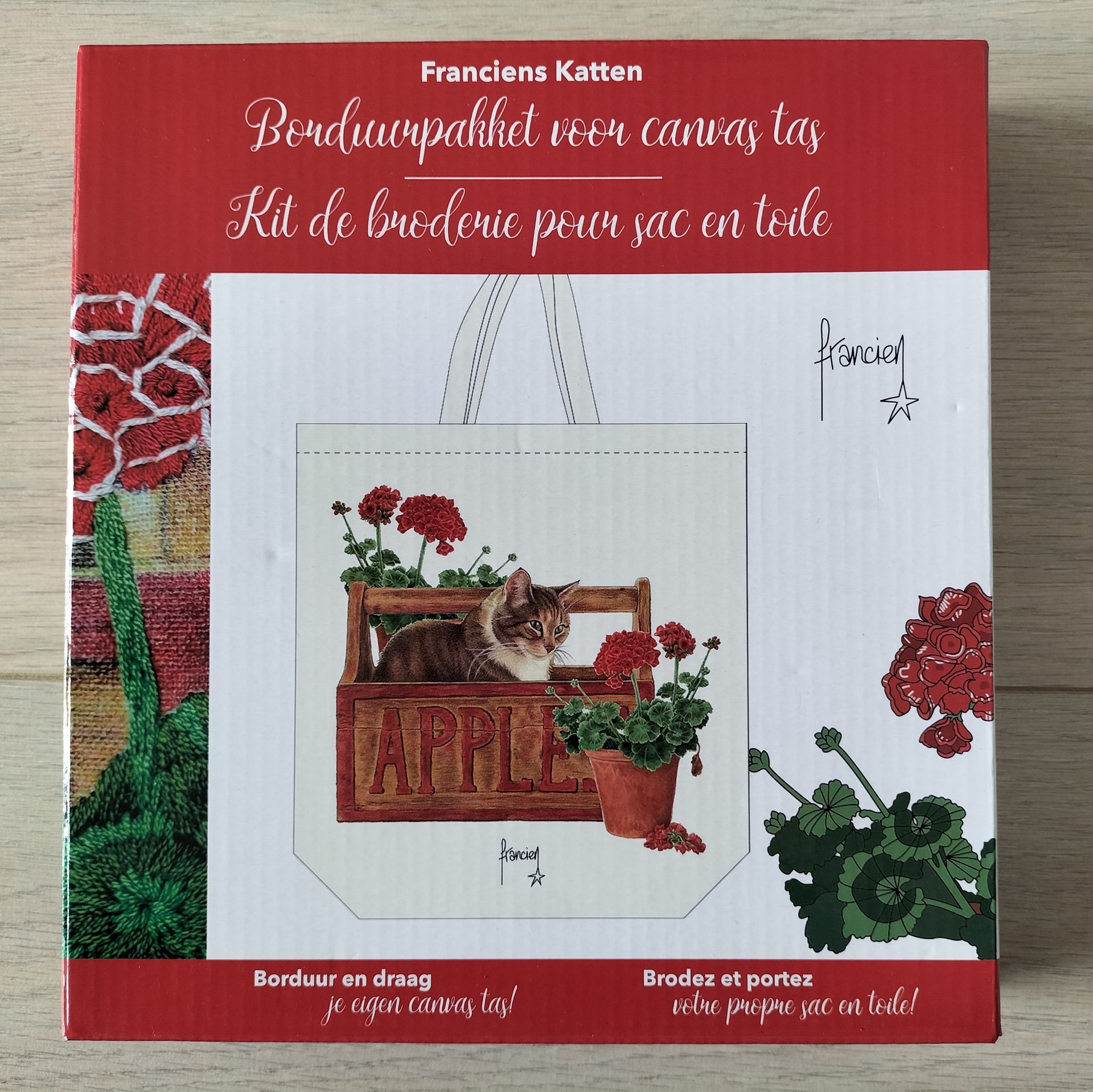 Doos met kruissteekpakket, met kat en bloemen op een draagtas.