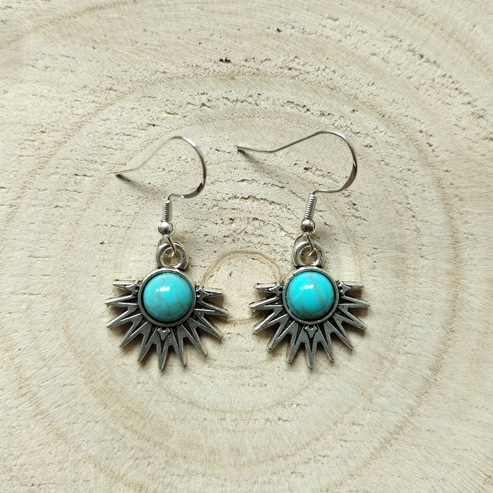 Zilverkleurige oorbellen met Tibetaanse halve zon met turquoise steentje en zilveren oorhaakje.