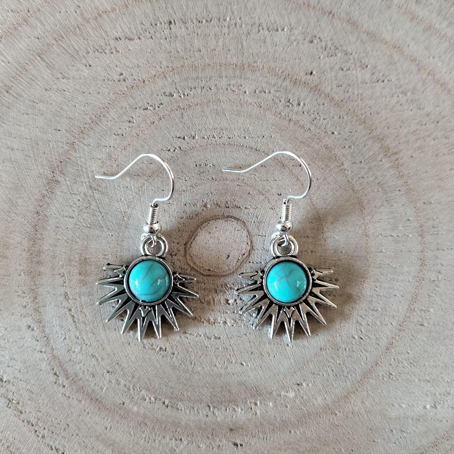 Zilverkleurige oorbellen met Tibetaanse halve zon met turquoise steentje, hypoallergeen.