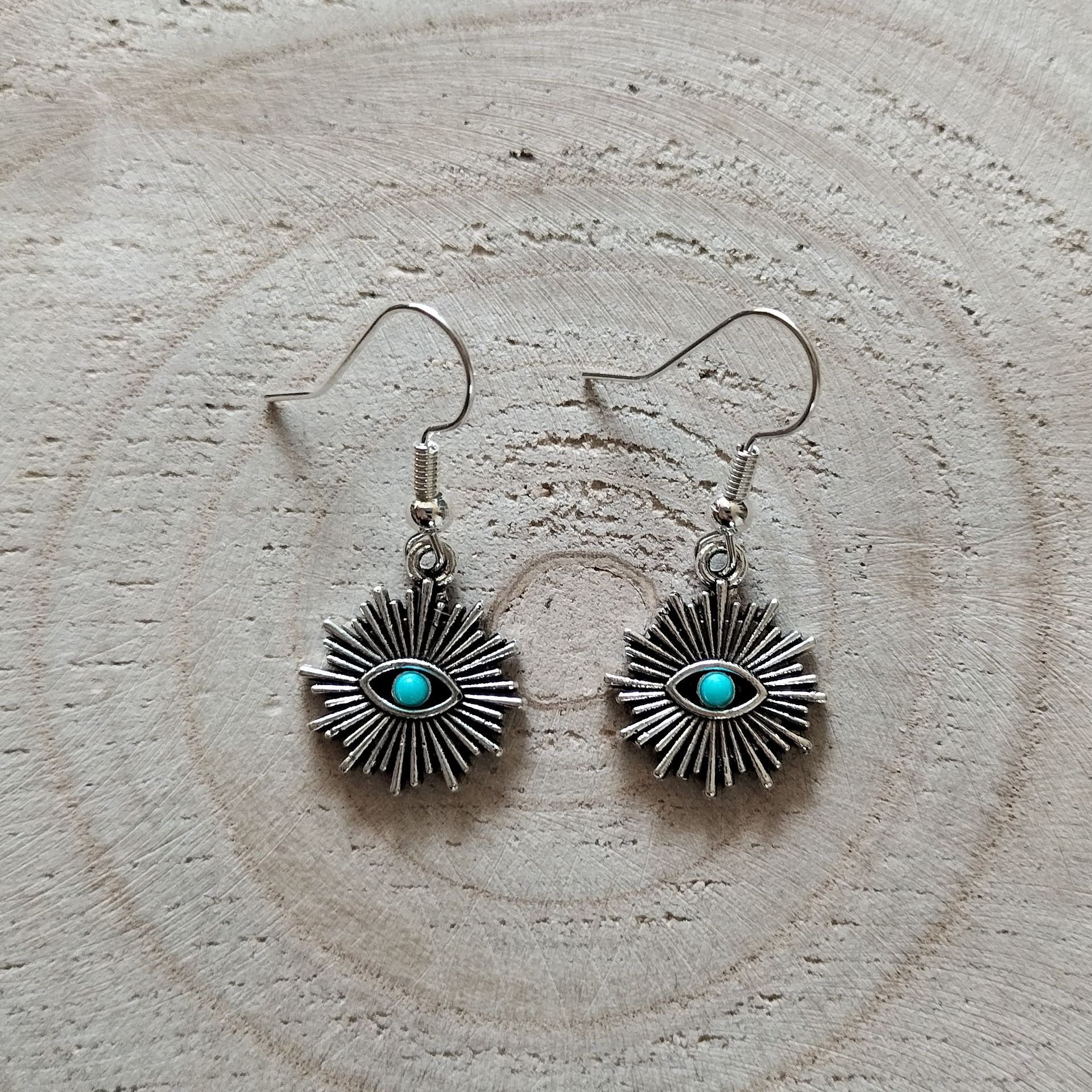 Zilverkleurige oorbellen met zonneoog en turquoise steentje, hypoallergeen.