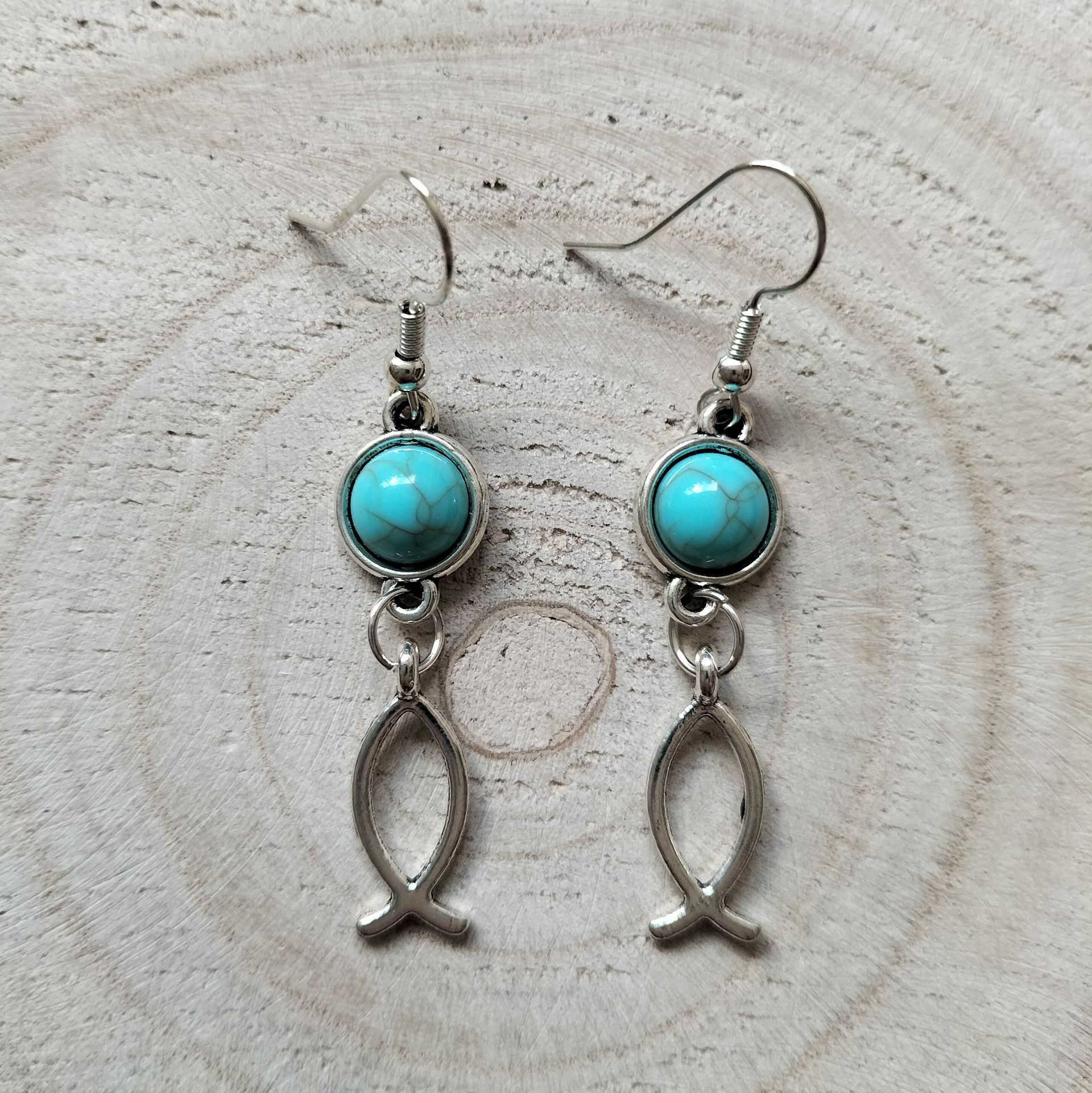 Zilverkleurige oorbellen met rond turquoise steentje en ichthus visje,hypoallergeen.
