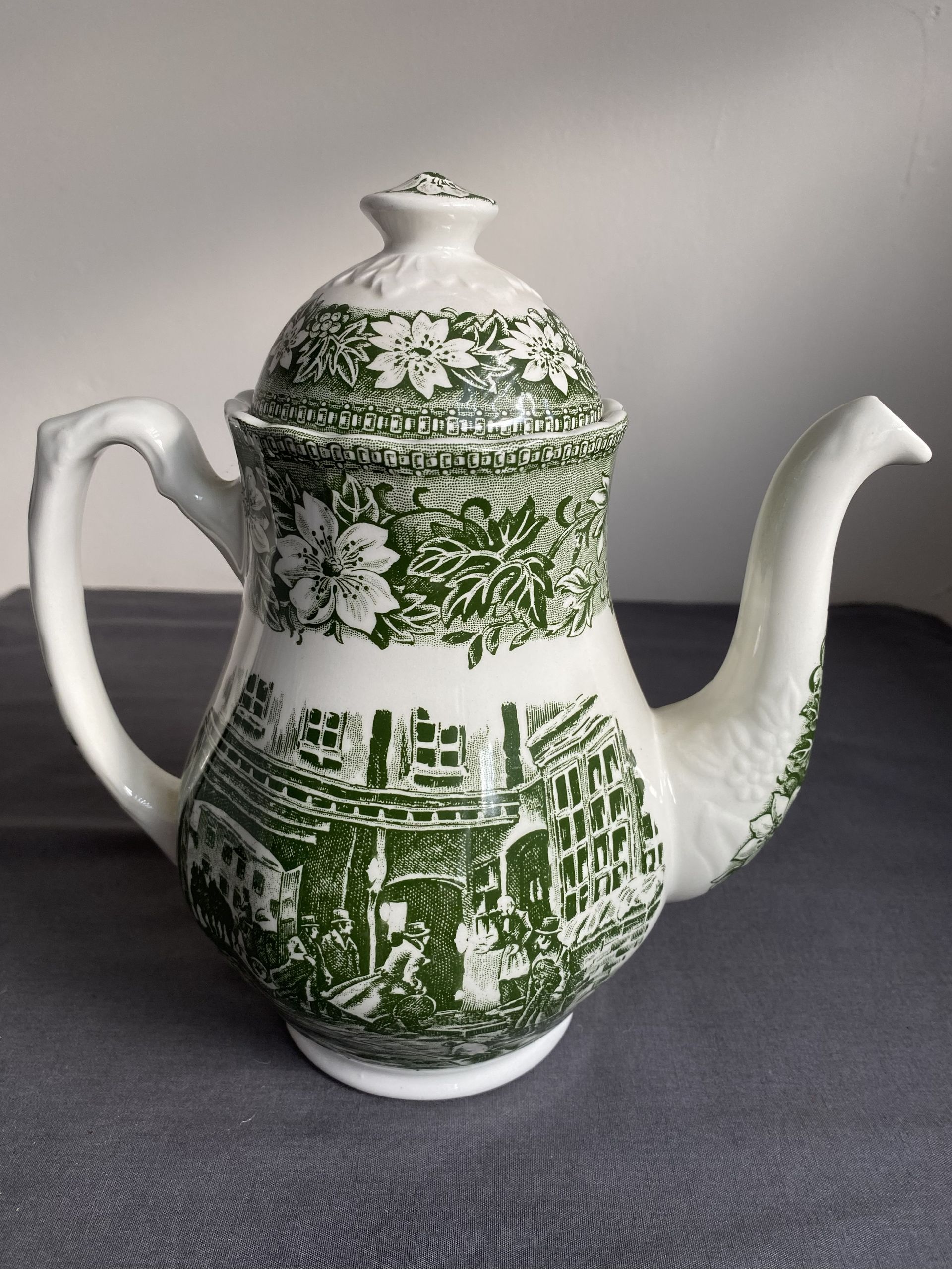 Vintage groen-witte porseleinen koffiepot met deksel, versierd met een landschapsmotief.