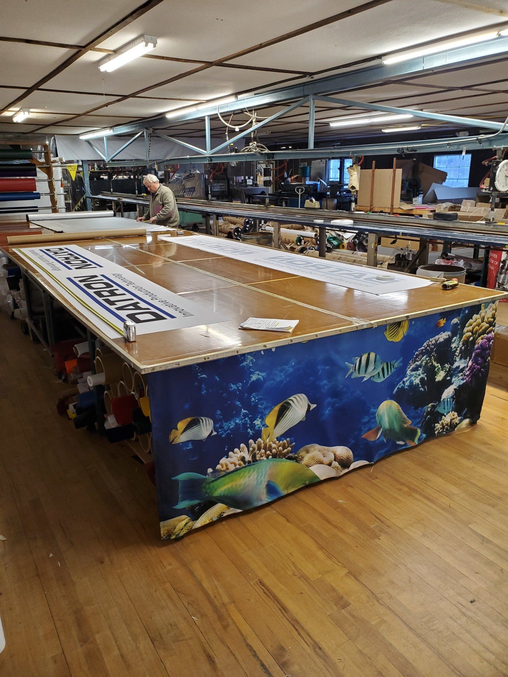 A large table with a picture of fish on it in a warehouse