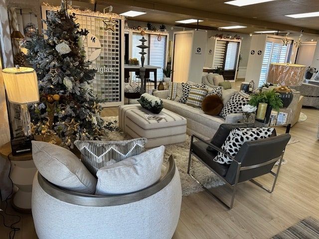 Interior design showroom with furniture, a flocked Christmas tree, and neutral color scheme.
