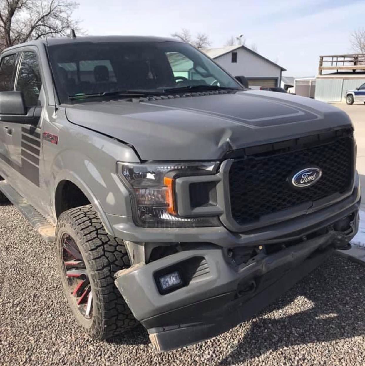 A ford truck is parked in a gravel lot