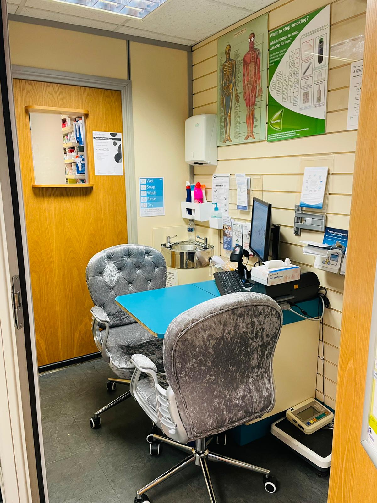 Consultation area in Ramzy's Pharmacy with anatomical charts on the wall and seating for patients, highlighting the ear clinic services.