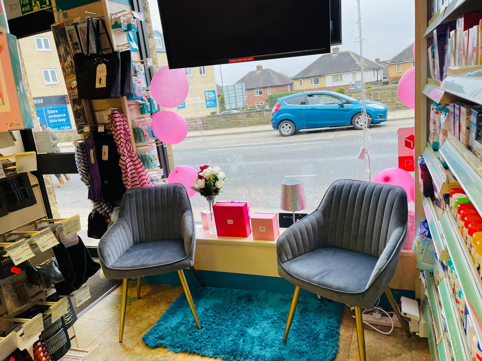 Cozy seating area in the pharmacy decorated with balloons and cards, next to shelves of ear care products.