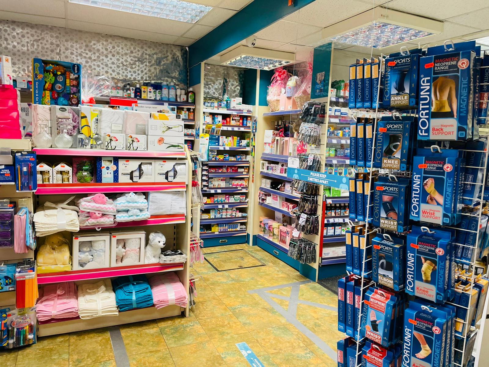 Pharmacy shelves stocked with various health, wellness, and hygiene products, showing a well-organized retail area