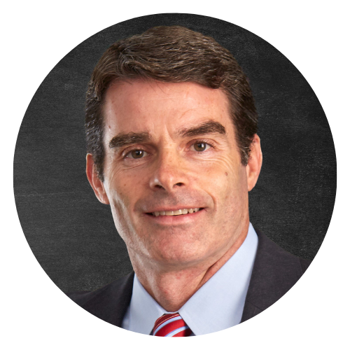 Headshot of a man in a suit and striped tie against a dark gray background