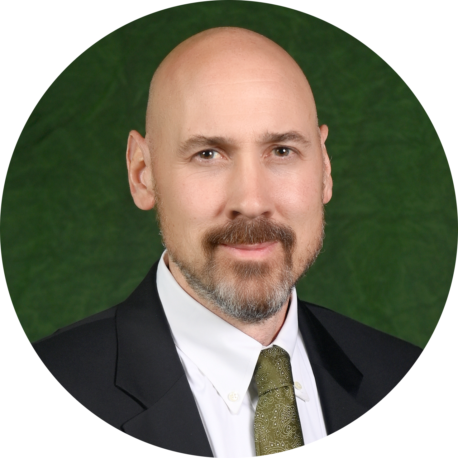 Headshot of a man in a suit and tie against a green background