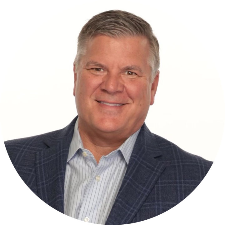 Smiling man in a navy plaid suit jacket and striped shirt on a white background