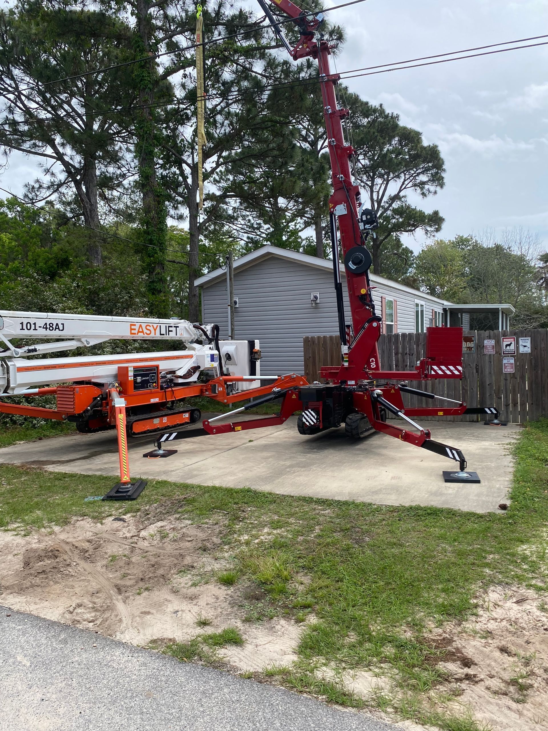 A red crane is parked in front of a house.