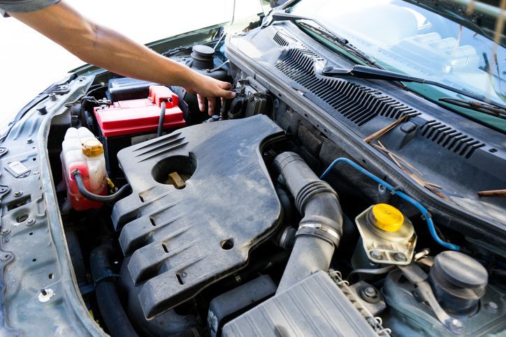 a man is working on the engine of a car .
