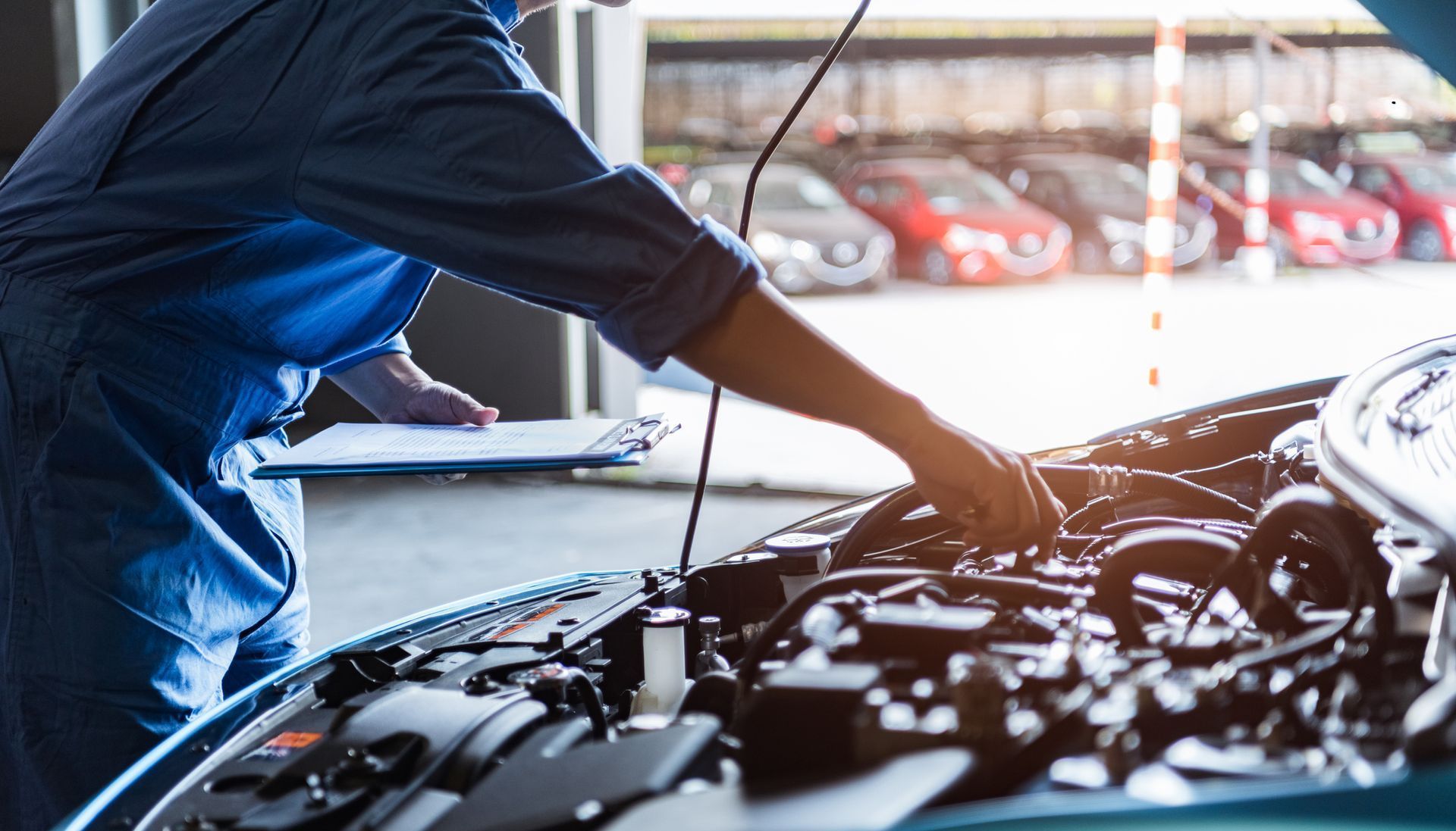 a mechanic is working on the engine of a car in a garage .