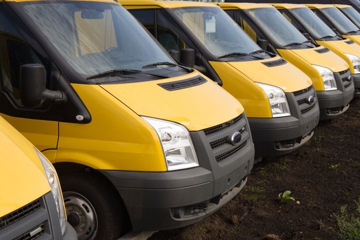 a row of yellow vans are parked next to each other