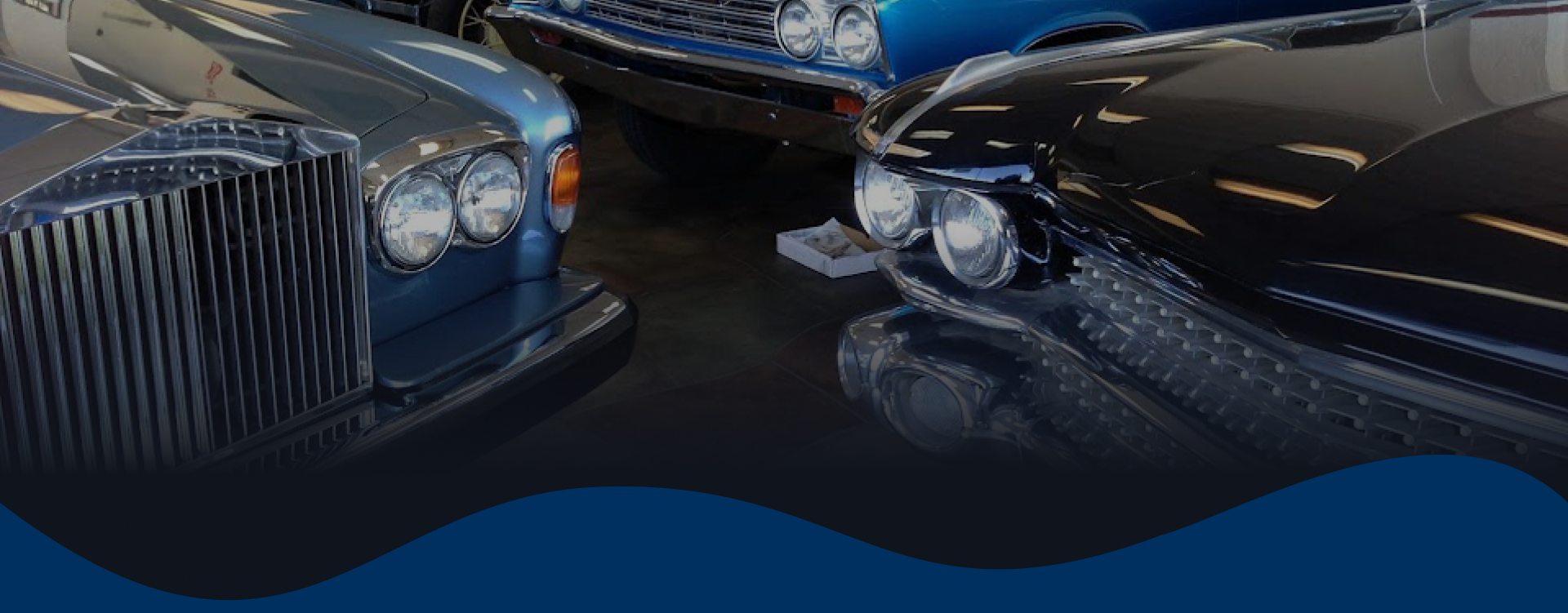 Mechanics working on cars in a repair shop; open hoods, tools, white uniforms, blue and white vehicles | Gilroy Car Care