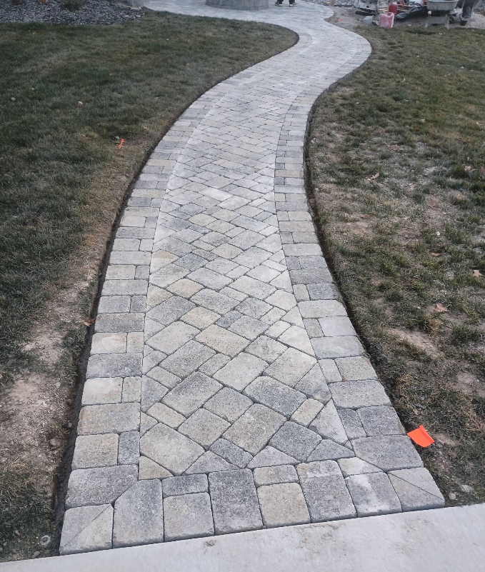 Curved light stone walkway through grass in a park or yard