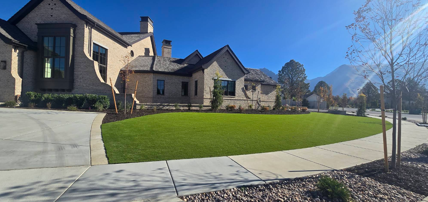 Suburban house with a neatly landscaped green lawn under a clear blue sky