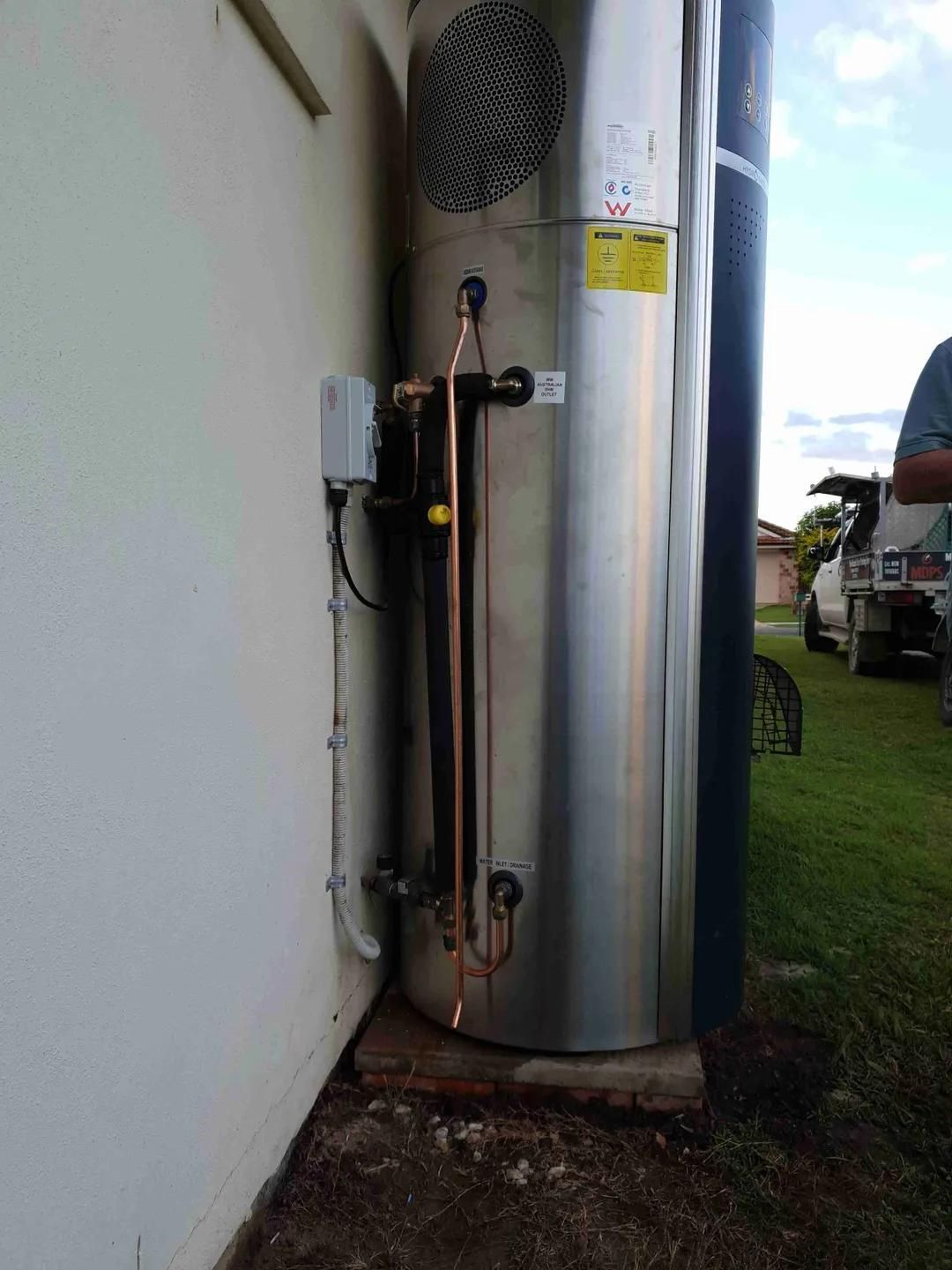 A Stainless Steel Water Heater Is Sitting on The Side of A Building — Murwillumbah District Plumbing Service in Nunderi, NSW