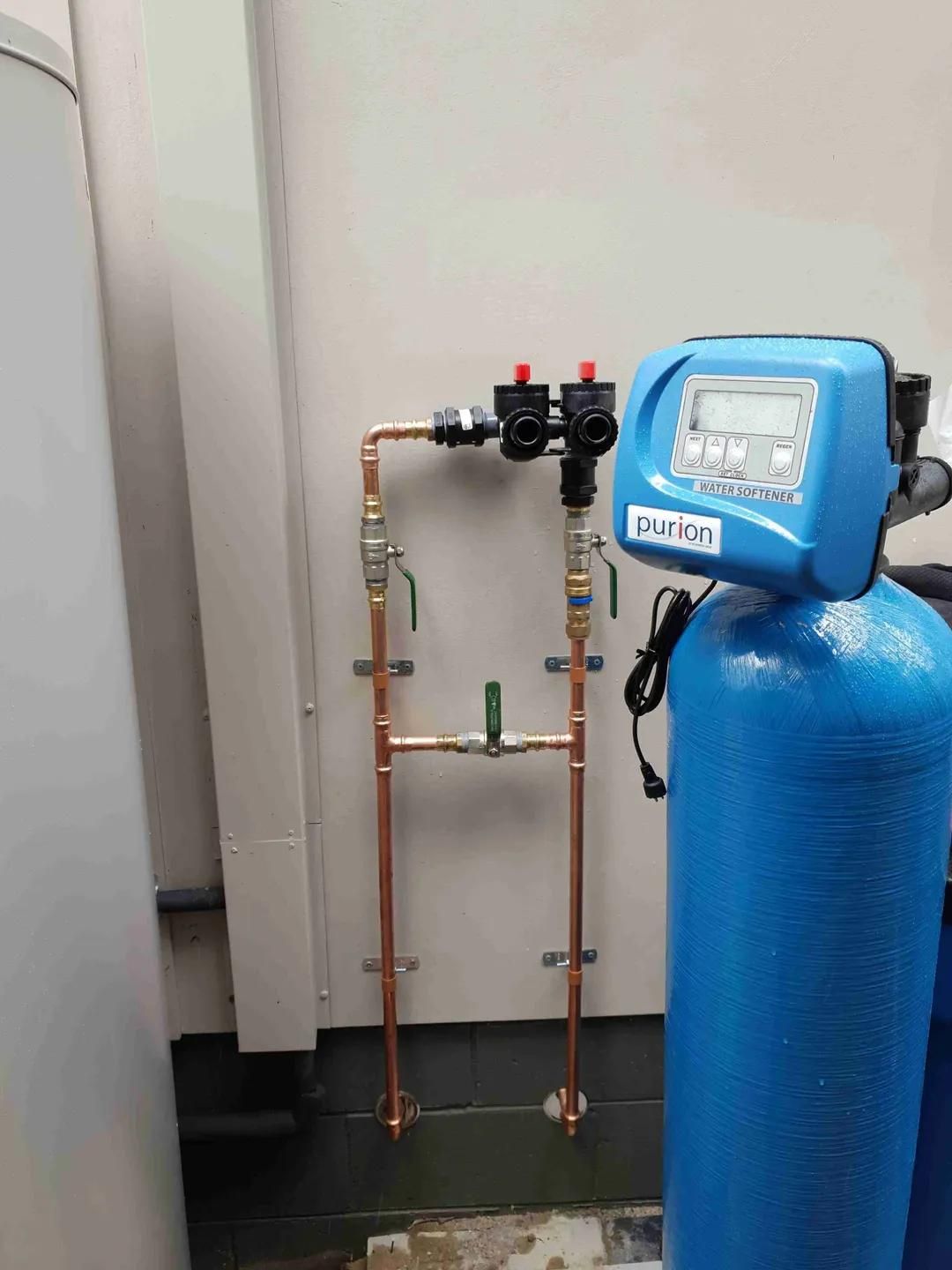 A Blue Water Filter Is Sitting Next to A Copper Pipe — Murwillumbah District Plumbing Service in Nunderi, NSW