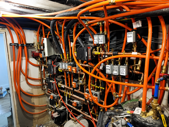 Orange cables and electrical equipment inside an industrial control panel cabinet.