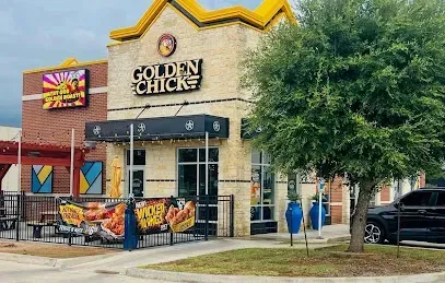 A golden chicks restaurant with a car parked in front of it.