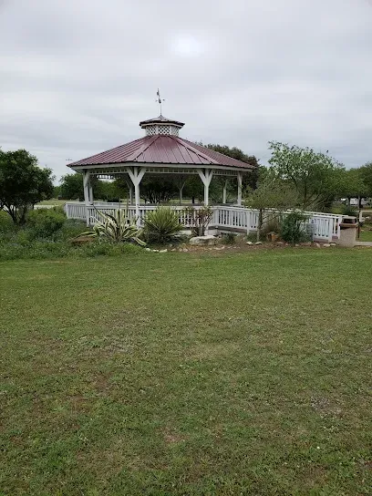 There is a gazebo in the middle of a grassy field.
