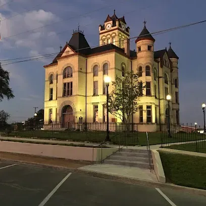A large building with a clock tower is lit up at night