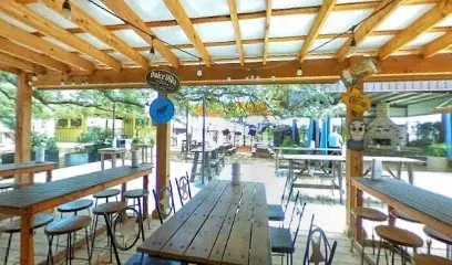 A restaurant with tables and chairs under a canopy.
