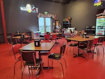 A restaurant with tables and chairs and a refrigerator.