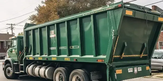 Roll Off dumpster rental A green dump truck is parked on the side of the road.