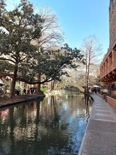 A river surrounded by trees and buildings in a city.