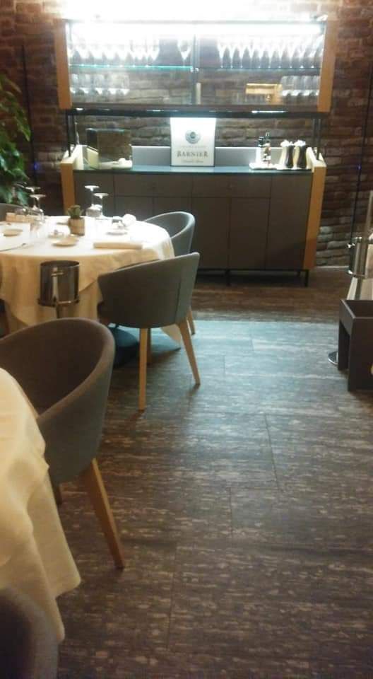 Sala da pranzo vuota di un ristorante con tavoli, sedie e bancone bar sullo sfondo.