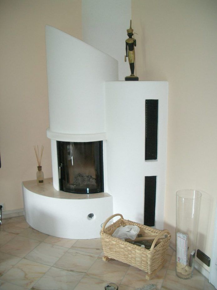 Moderner, weißer, geschwungener Kamin mit Fliesenboden, in einem minimalistischen Raum