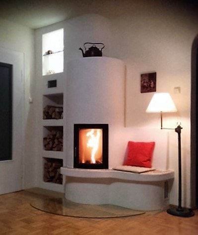 Modernes Wohnzimmer mit weißem Kamin, Kissen, Stehlampe und geschwungener Bank an einer Glastür