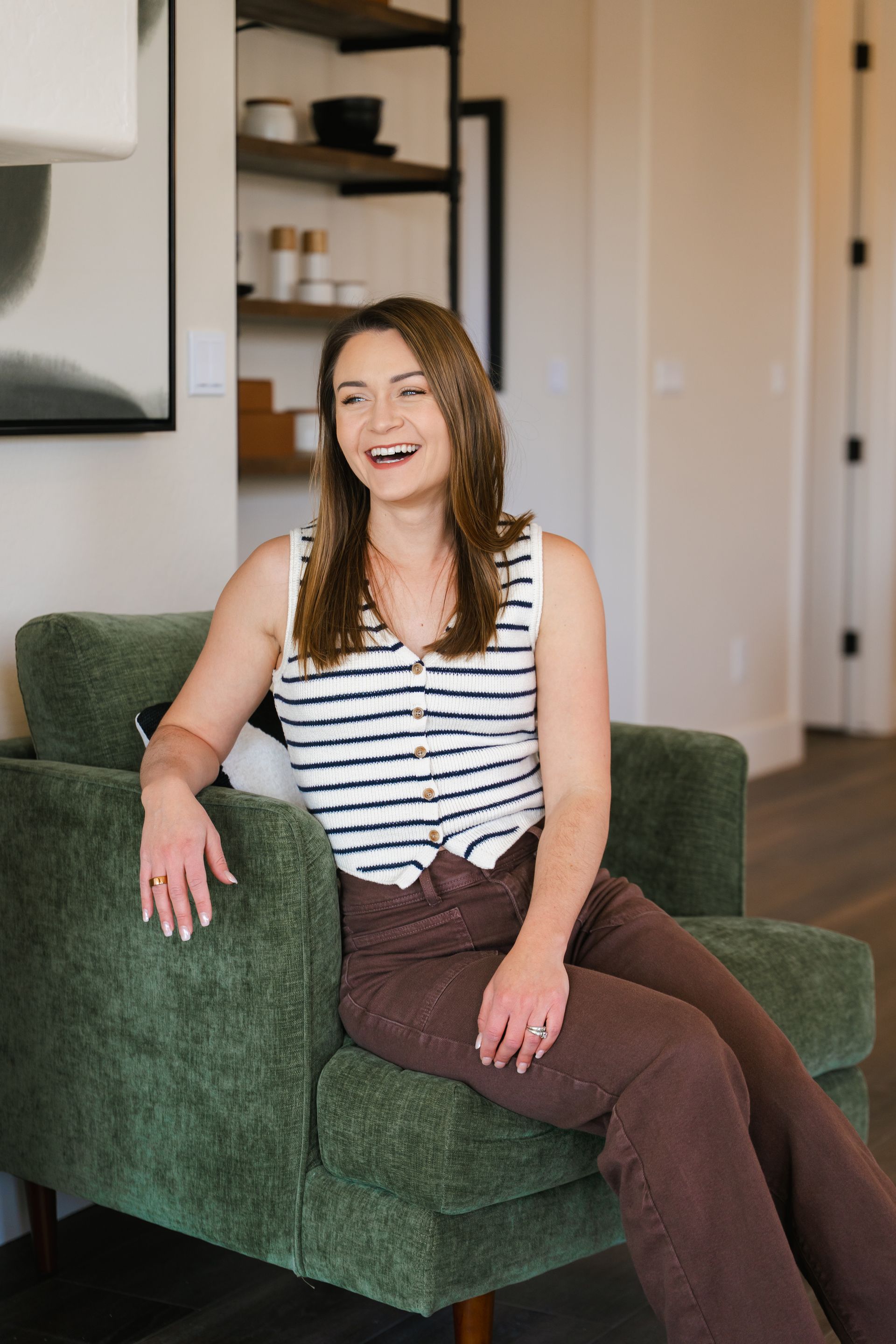 Bree is sitting in a green chair in a living room.