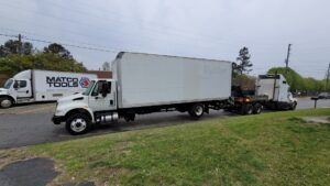 Two moving trucks are parked on the side of the road.