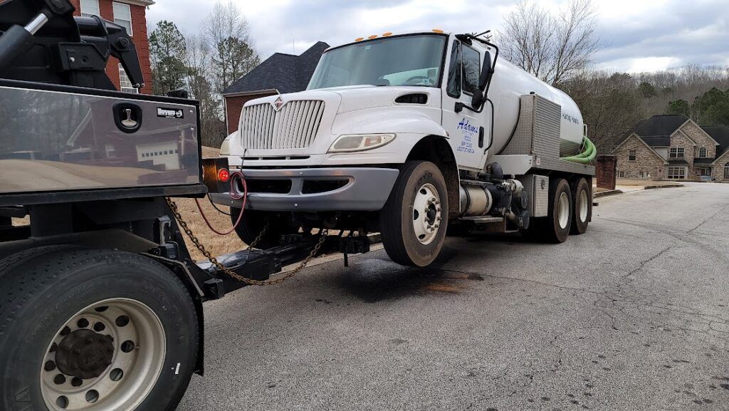 A white truck is being towed by a tow truck.