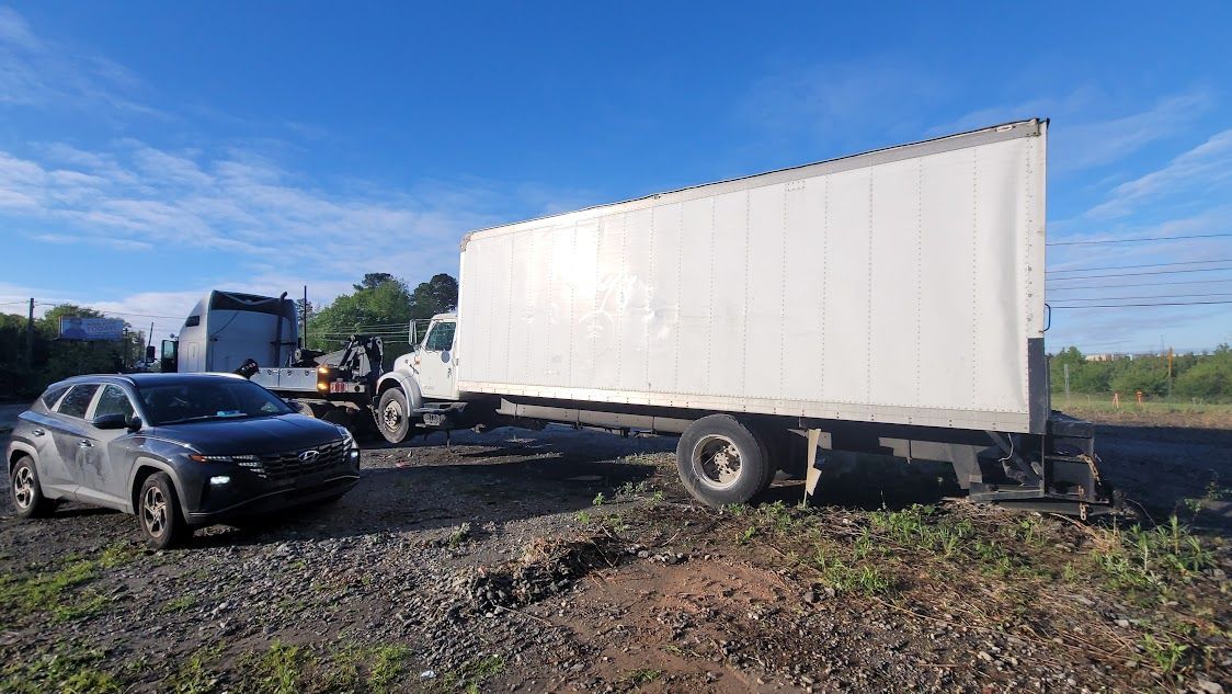A truck and a car in a gravel lot. A truck and a car in a gravel lot.