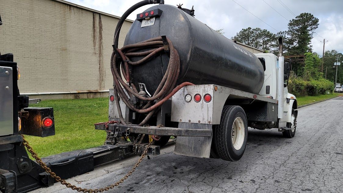 A vacuum truck is parked on the side of the road.