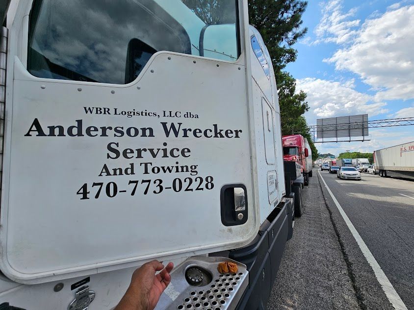 A white truck with Anderson Wrecker Service and Towing written on it A white truck with Anderson Wrecker Service and Towing written on it