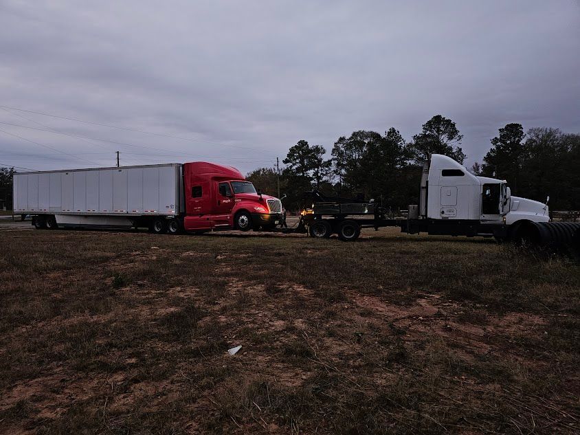 Two semi trucks are parked in a field. Two semi trucks are parked in a field.