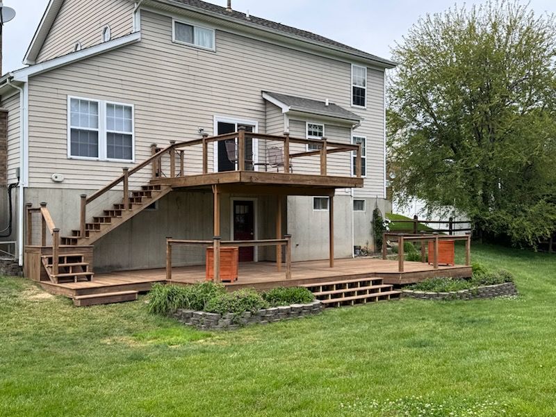 Cozy porch with wooden railing, hanging plants, and an American flag on a white house.
