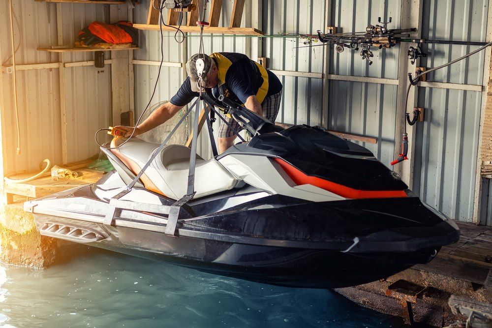 A Man is Working on a Jet Ski in a Garage — North Coast Storage in North Boambee Valley, NSW