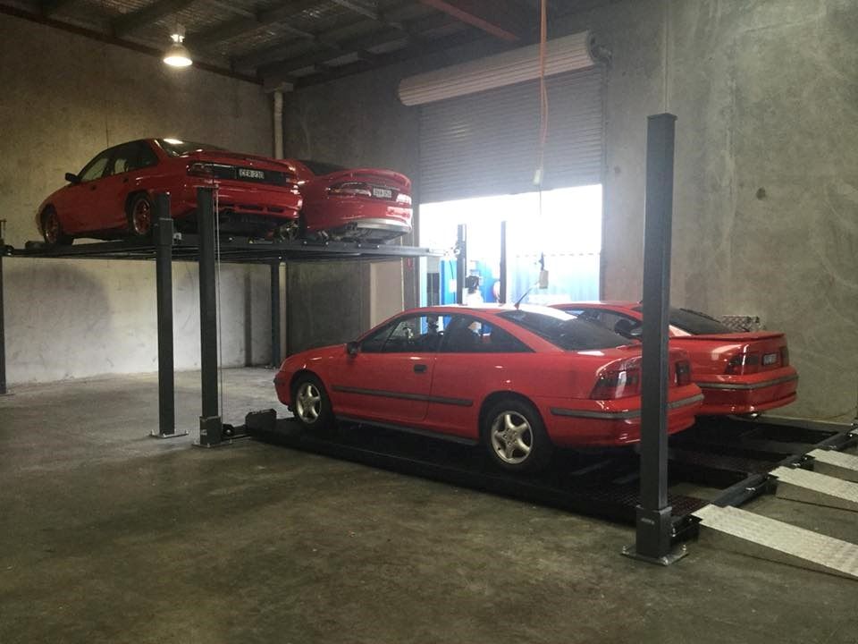 Two Red Cars Are Parked on a Lift in a Garage — North Coast Storage in North Boambee Valley, NSW