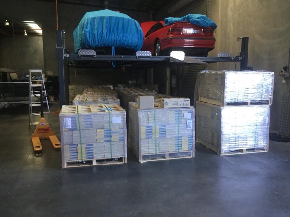A Red Car is Parked Under a Lift in a Garage — North Coast Storage in North Boambee Valley, NSW