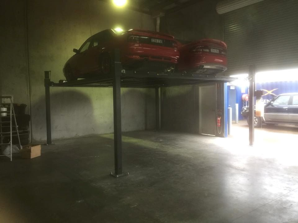 Two Cars Are Parked on a Lift in a Garage — North Coast Storage in North Boambee Valley, NSW